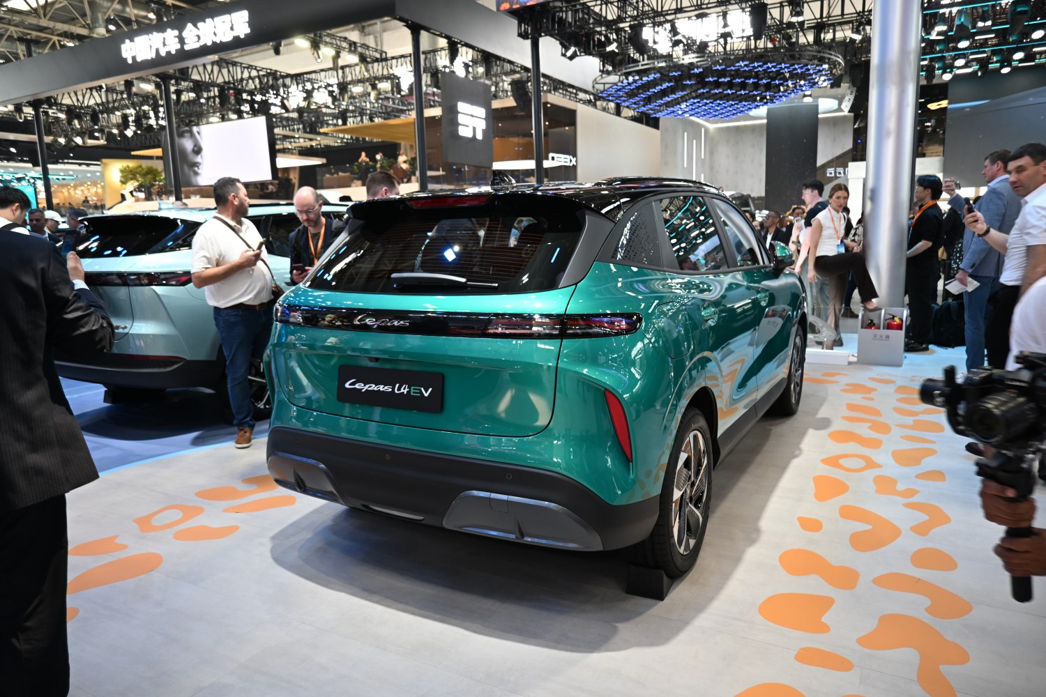 Rear perspective of a green electric SUV with sleek taillights and sporty bumper.