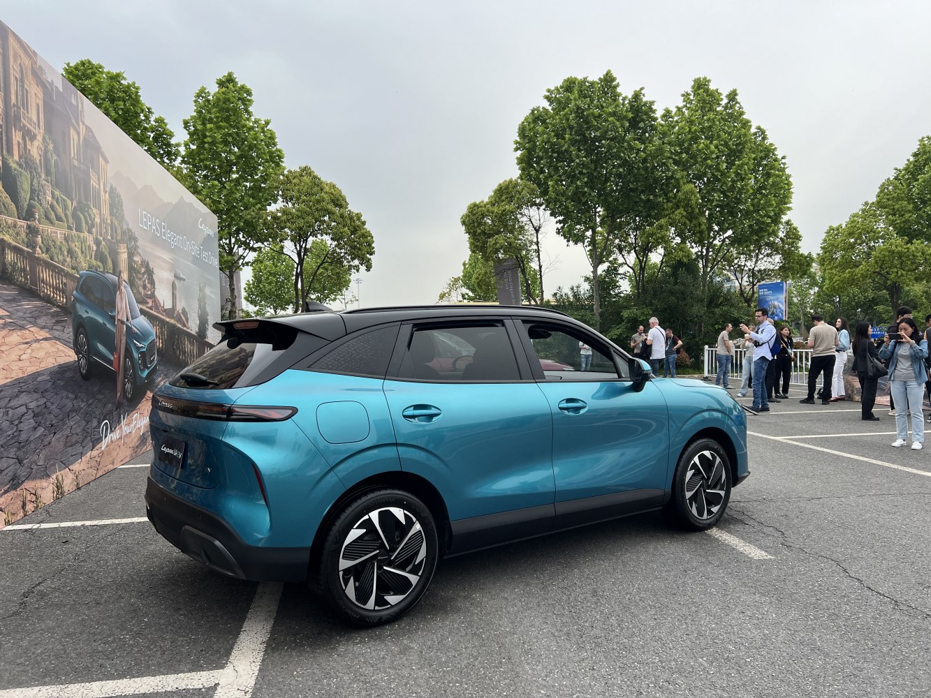 Rear-side view of a blue and black two-tone modern SUV with sleek aerodynamic features.