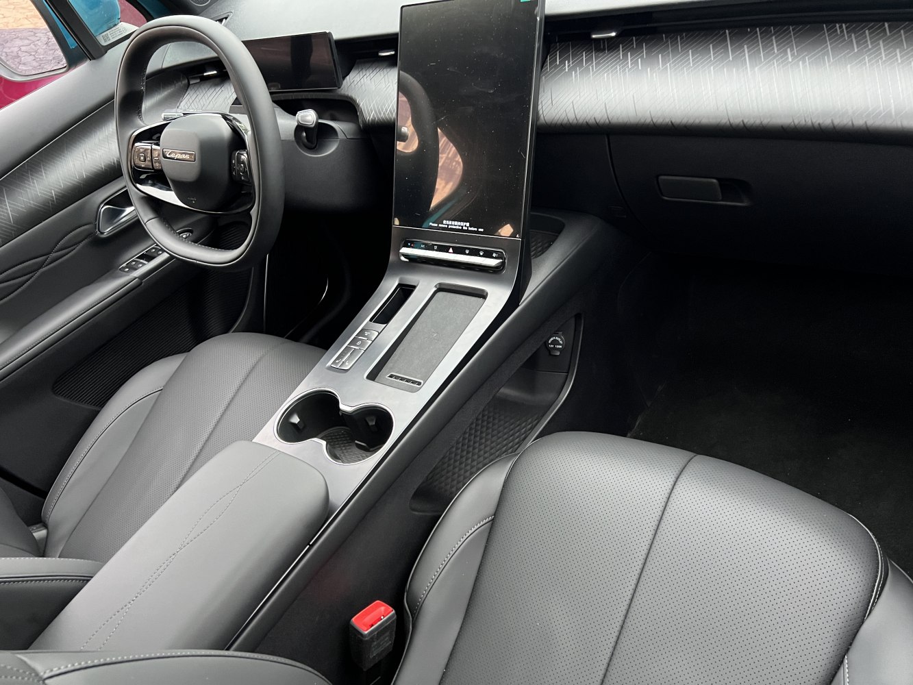 Car interior with large vertical infotainment screen and leather seats