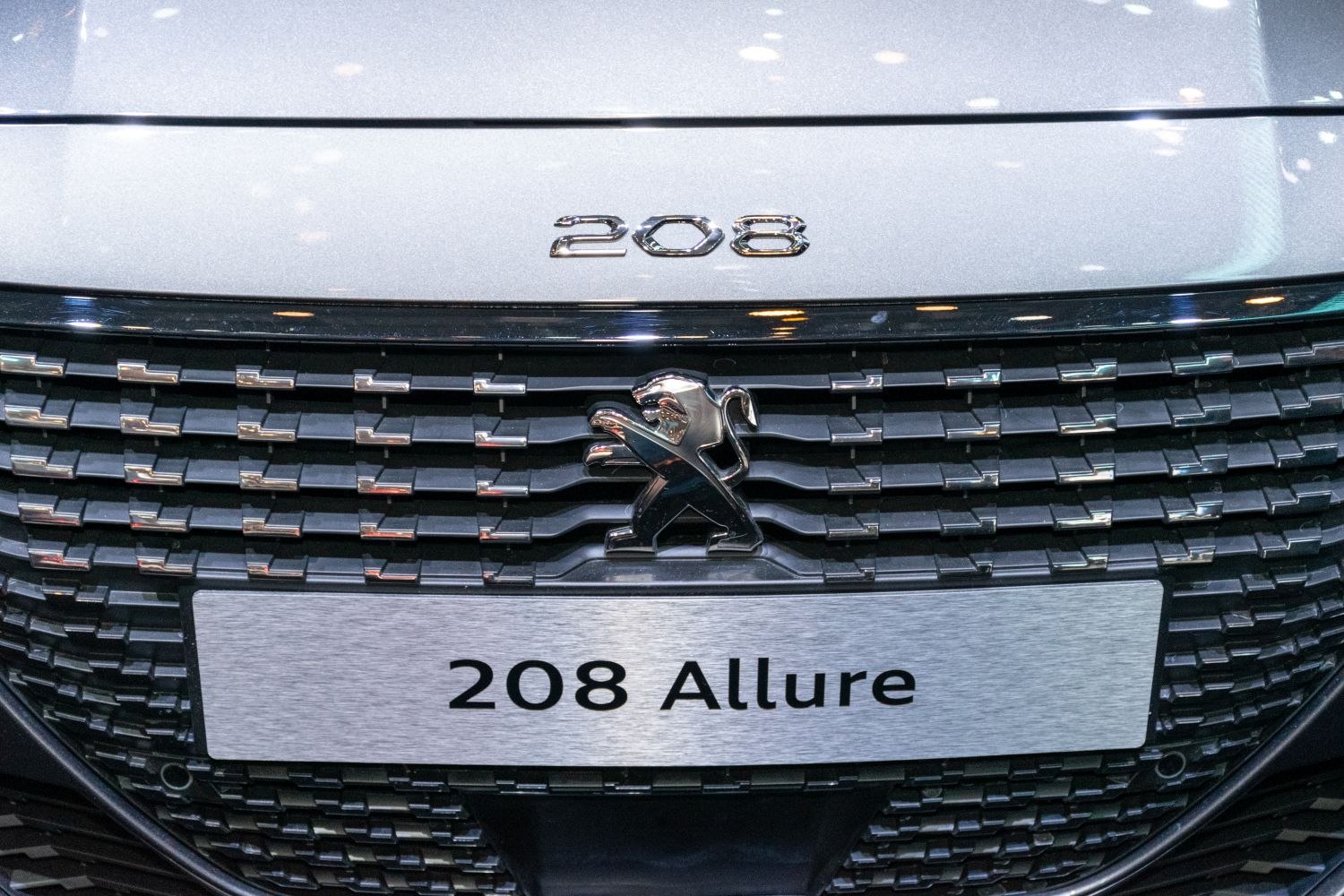 Close-up of Peugeot 208 front grille, badge, and lion emblem