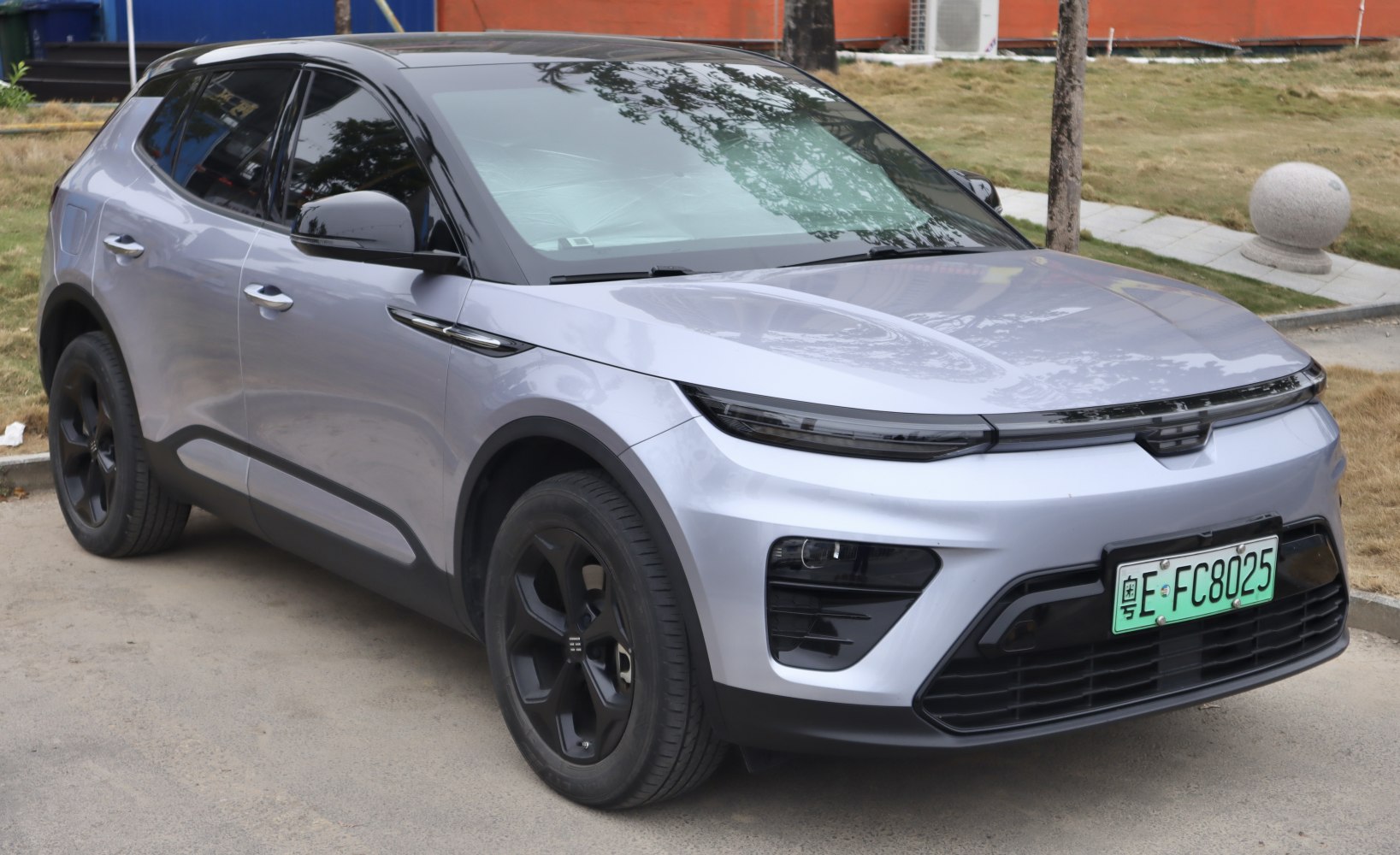 Modern electric SUV front view with split headlights and black alloy wheels