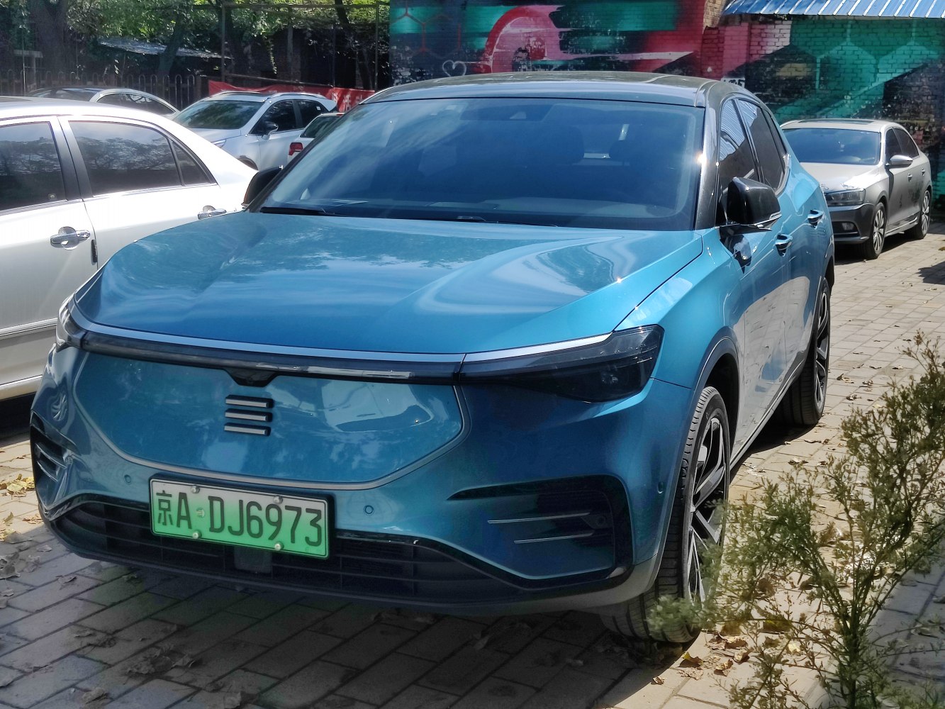 Sleek electric SUV front with closed grille and LED headlights