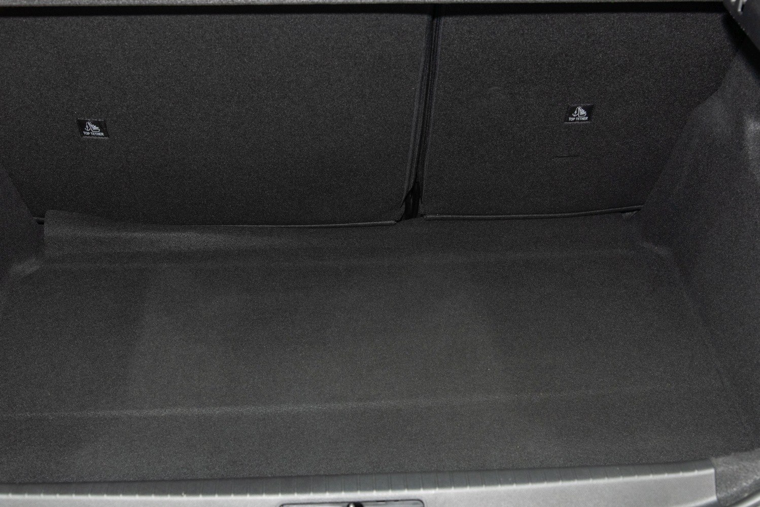 Spacious and carpeted car trunk interior with top tether anchors