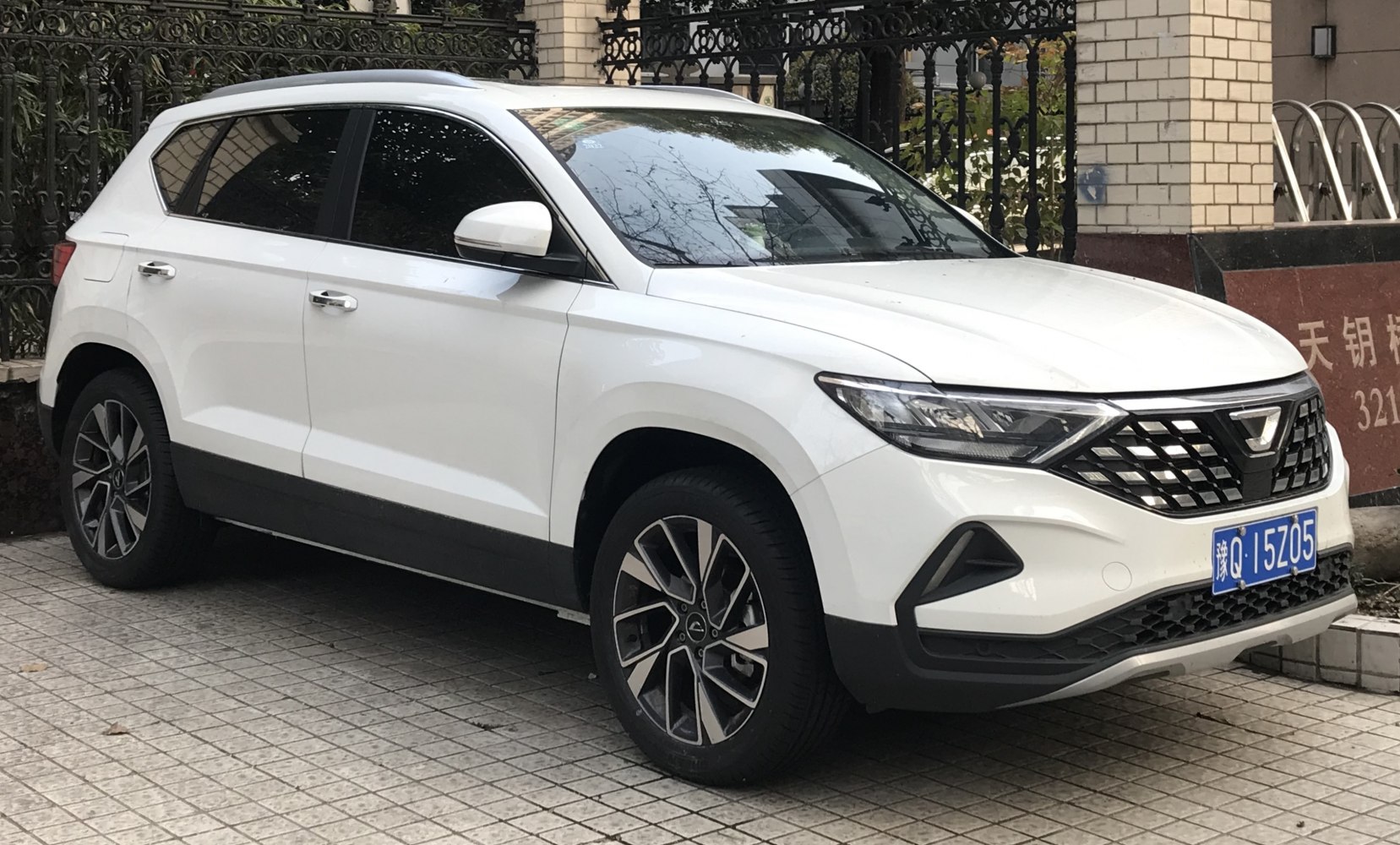 White modern SUV with angular headlights and detailed grille.
