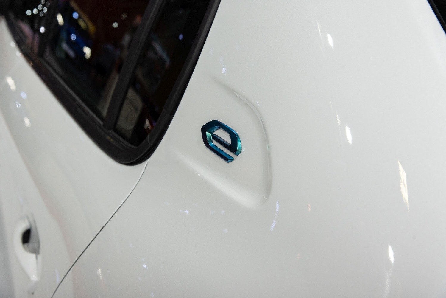 Close-up of electric 'e' emblem on white car body panel