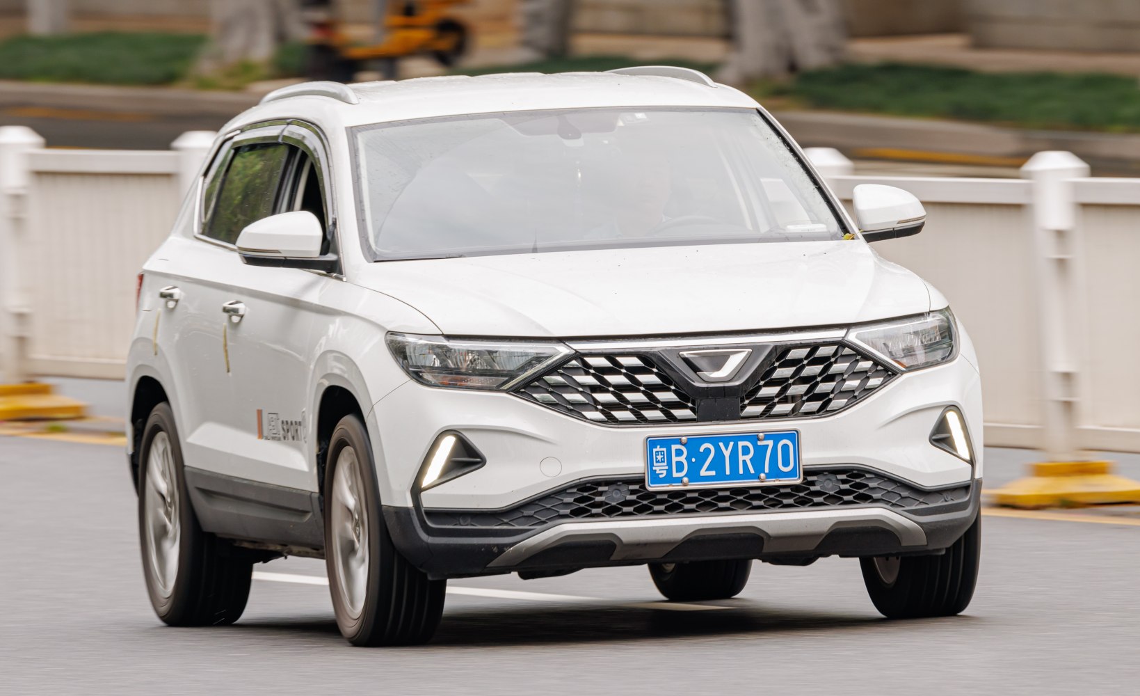 Front of white SUV with diamond-pattern grille and LED fog lights