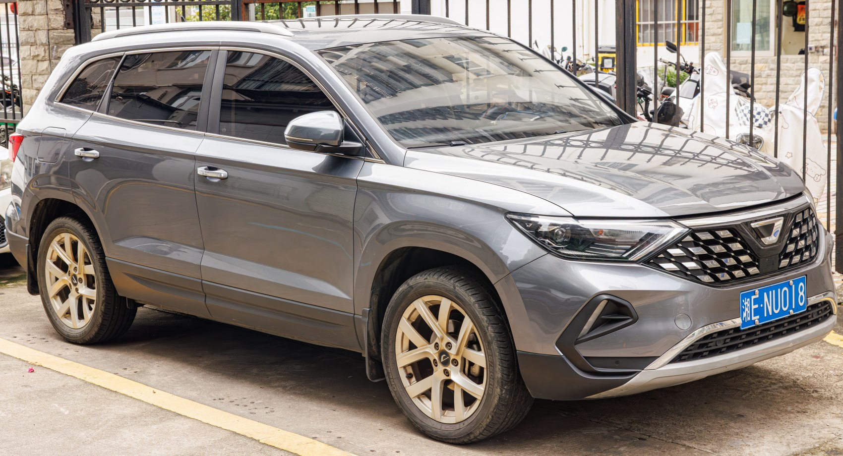 Front side view of a sleek SUV with modern headlights and alloy wheels