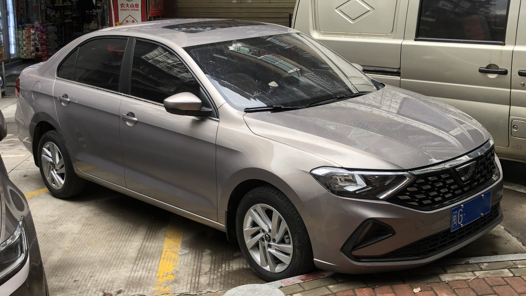 Front side view of a 2019 model compact sedan with angular headlights and alloy wheels