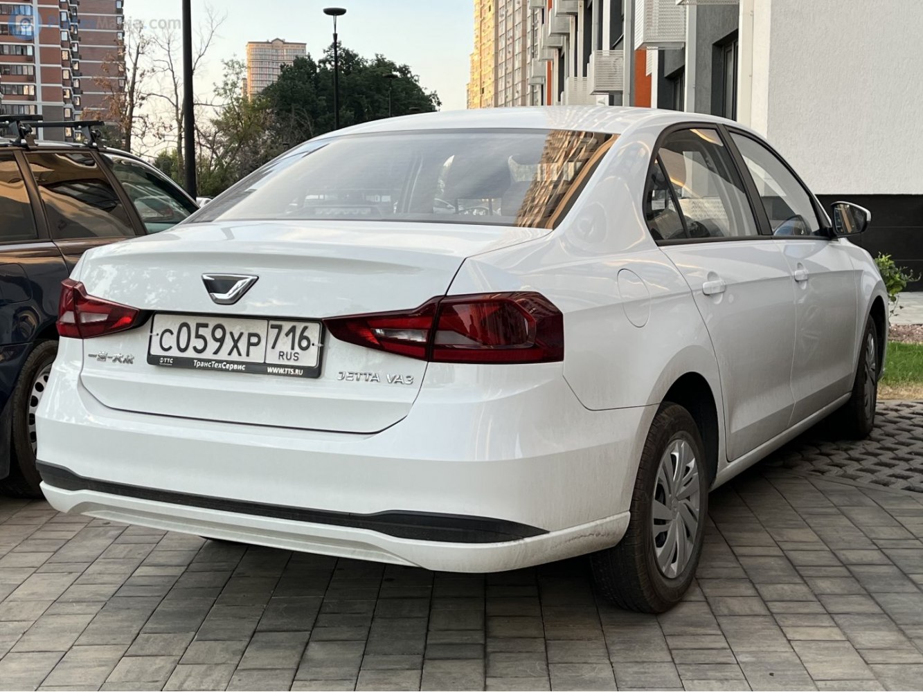 White sedan rear with red tail lights and smooth rear bumper design