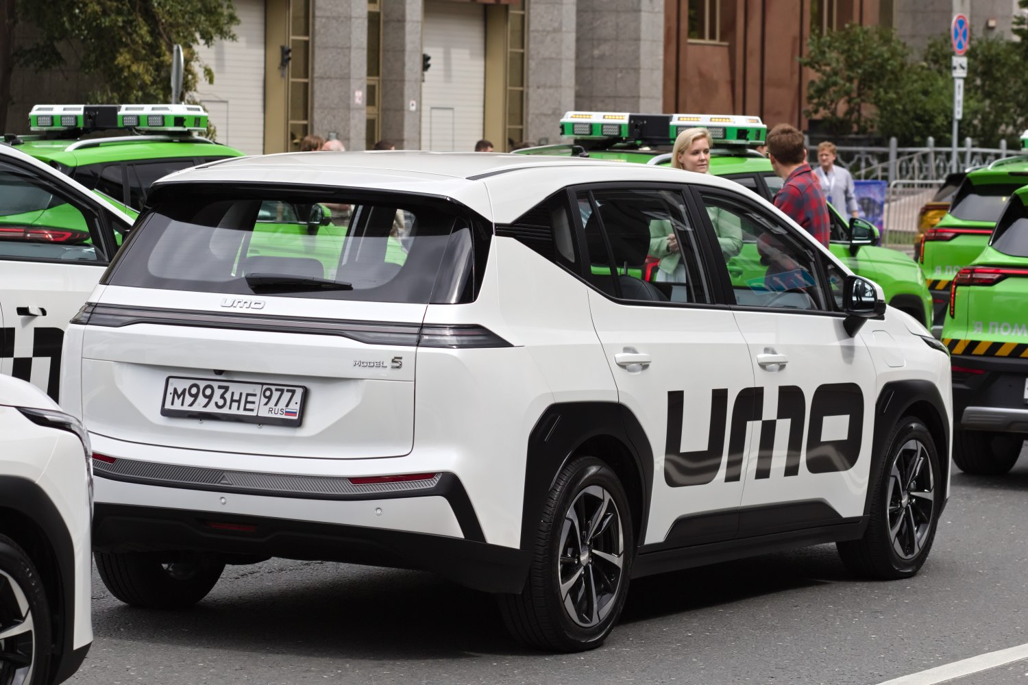 Rear-side view of white electric SUV with bold UMO branding