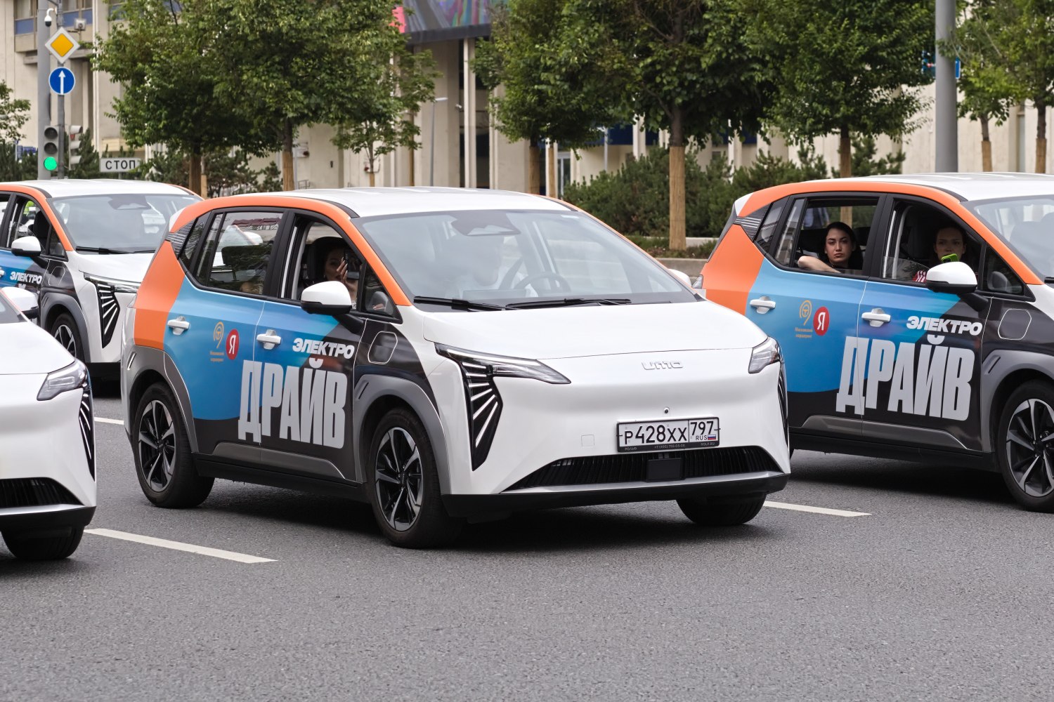 Front and side views of a compact electric vehicle with distinctive lights and side graphics