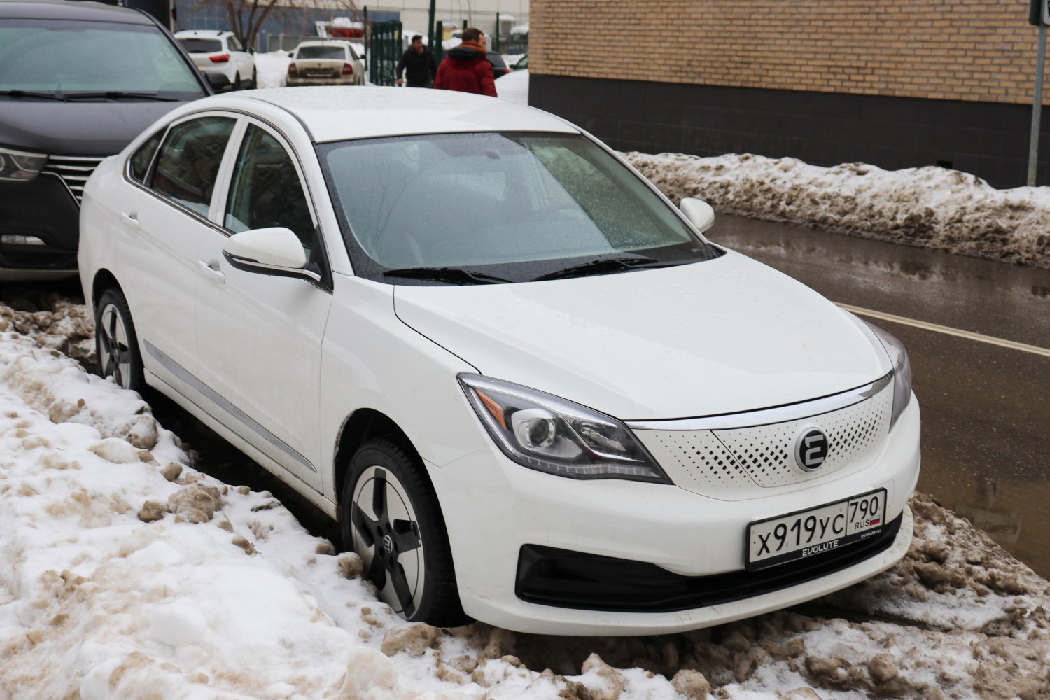 White electric sedan with unique perforated front grille and aerodynamic headlights