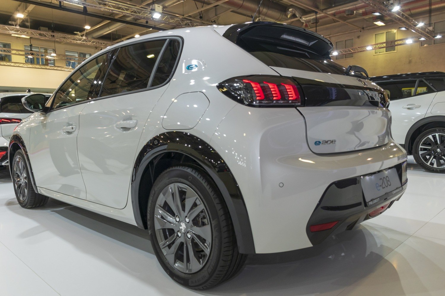 Rear-side view showing LED tail lights and aerodynamic shape of a compact electric hatchback.