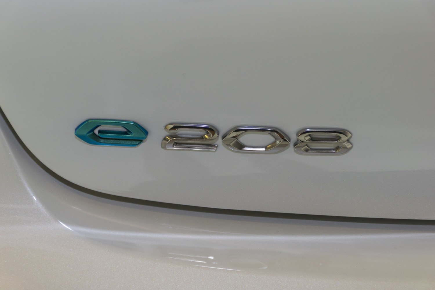 Close-up of electric e-208 chrome and blue emblem badge