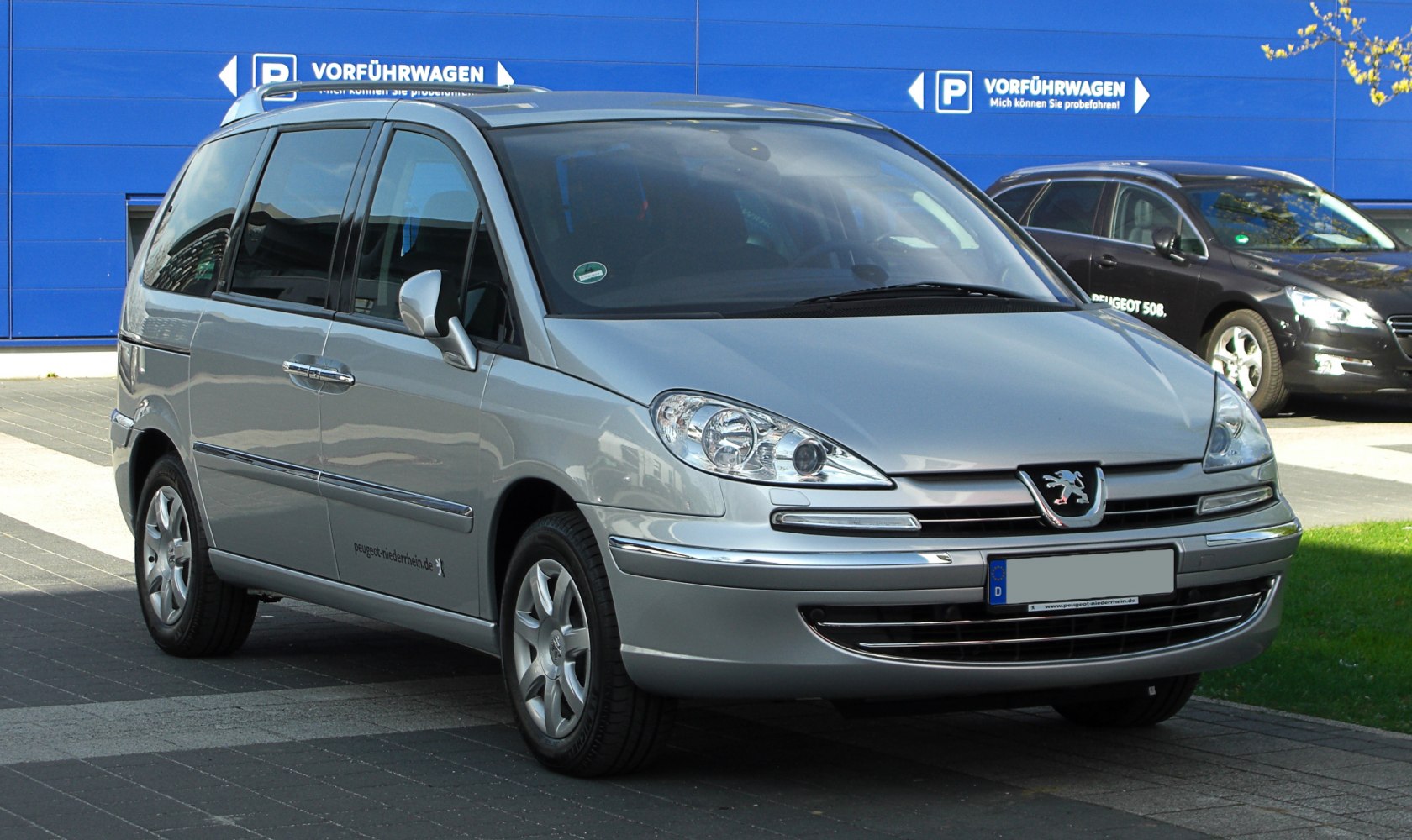 Front view of minivan focusing on headlights and grille design
