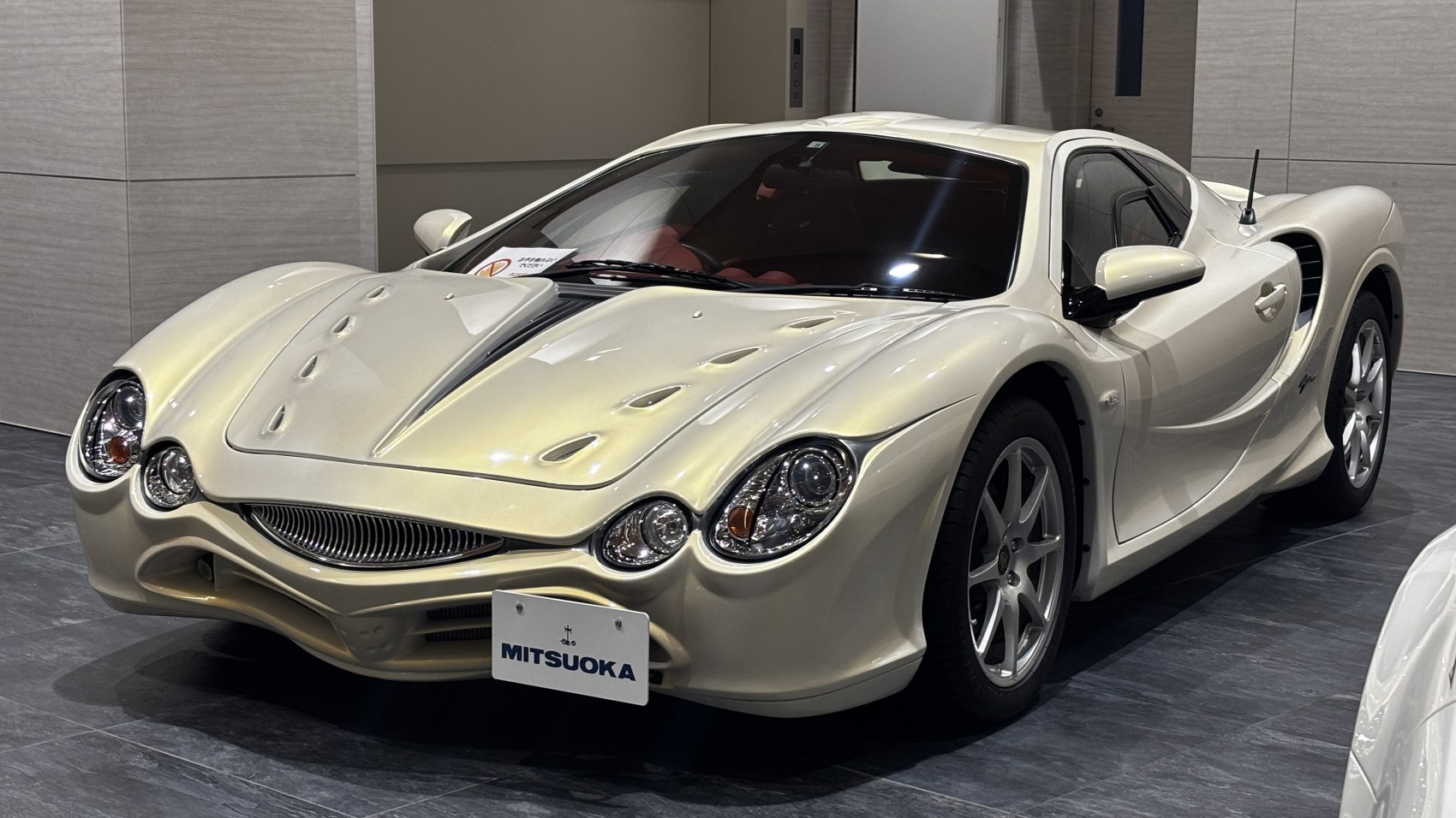 Vented hood and quad round headlights on a sleek sports coupe