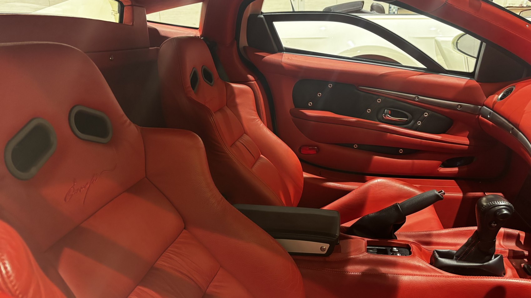 Red leather racing-style seats and manual gearshift interior