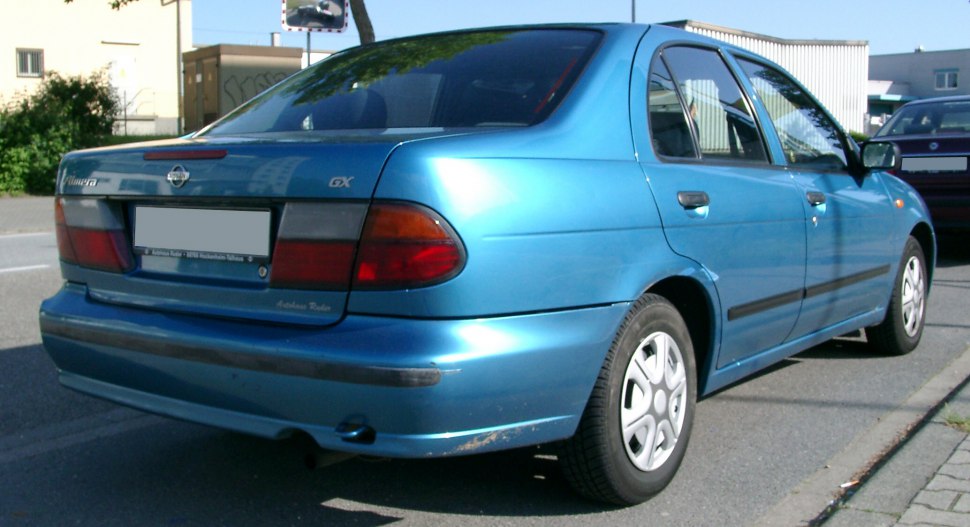 Rear-side view of a blue mid-1990s sedan showing taillights and wheel design