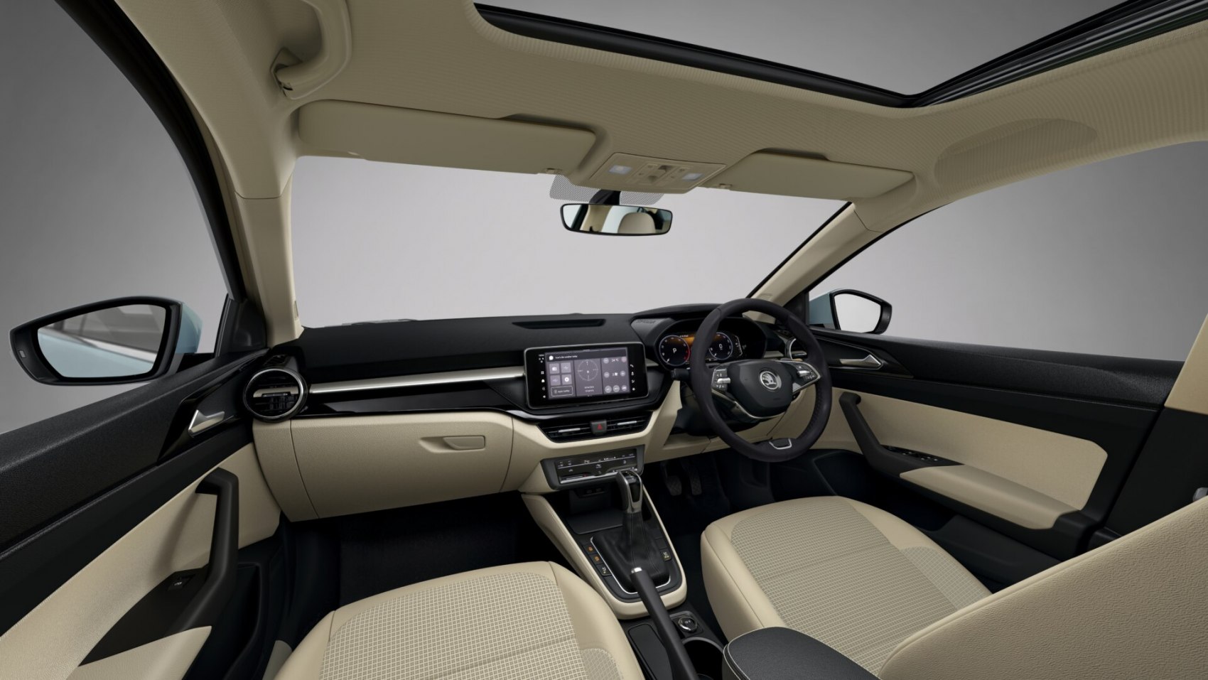 Car interior with beige seats, digital dashboard, touchscreen, and panoramic roof