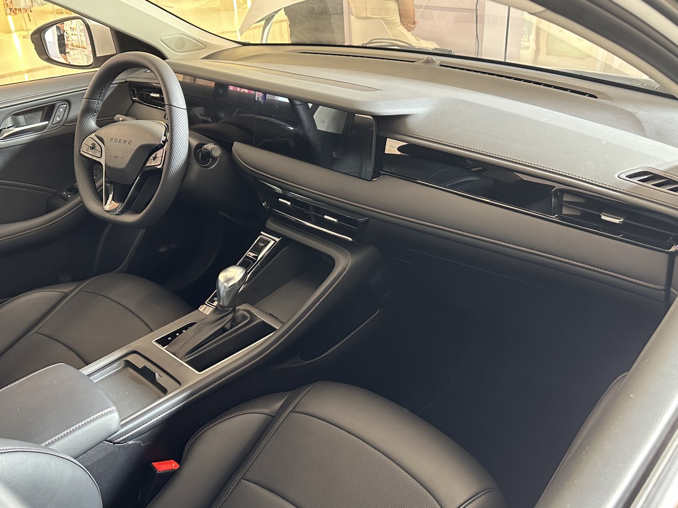 Steering wheel and wide digital dashboard display in a modern car interior