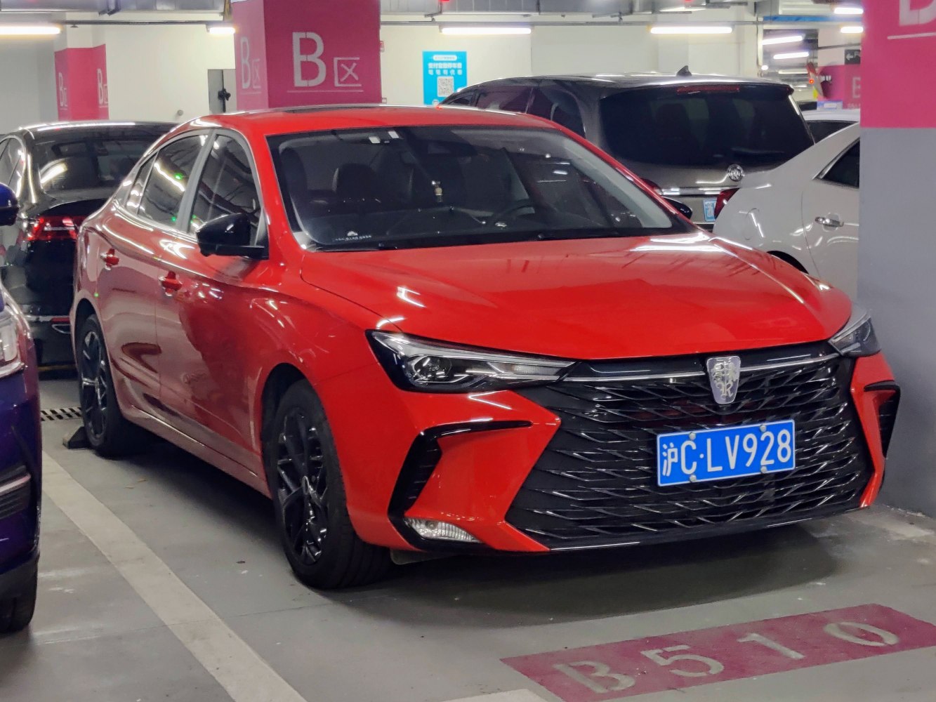 Red sedan with aggressive black grille and angular headlights