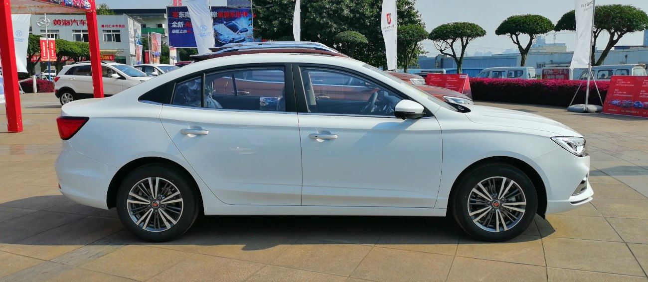 White mid-size sedan side profile with alloy wheels