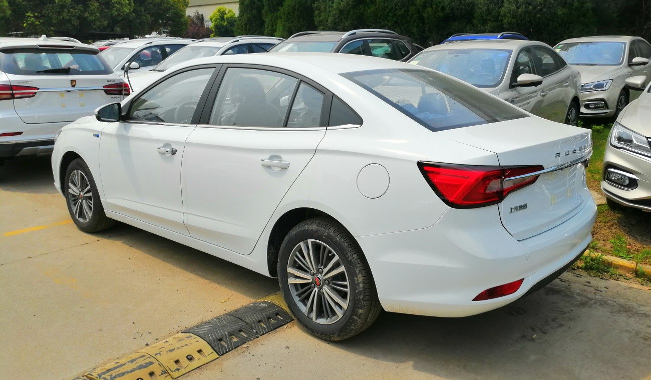 White sedan showcasing rear side profile and tail lights