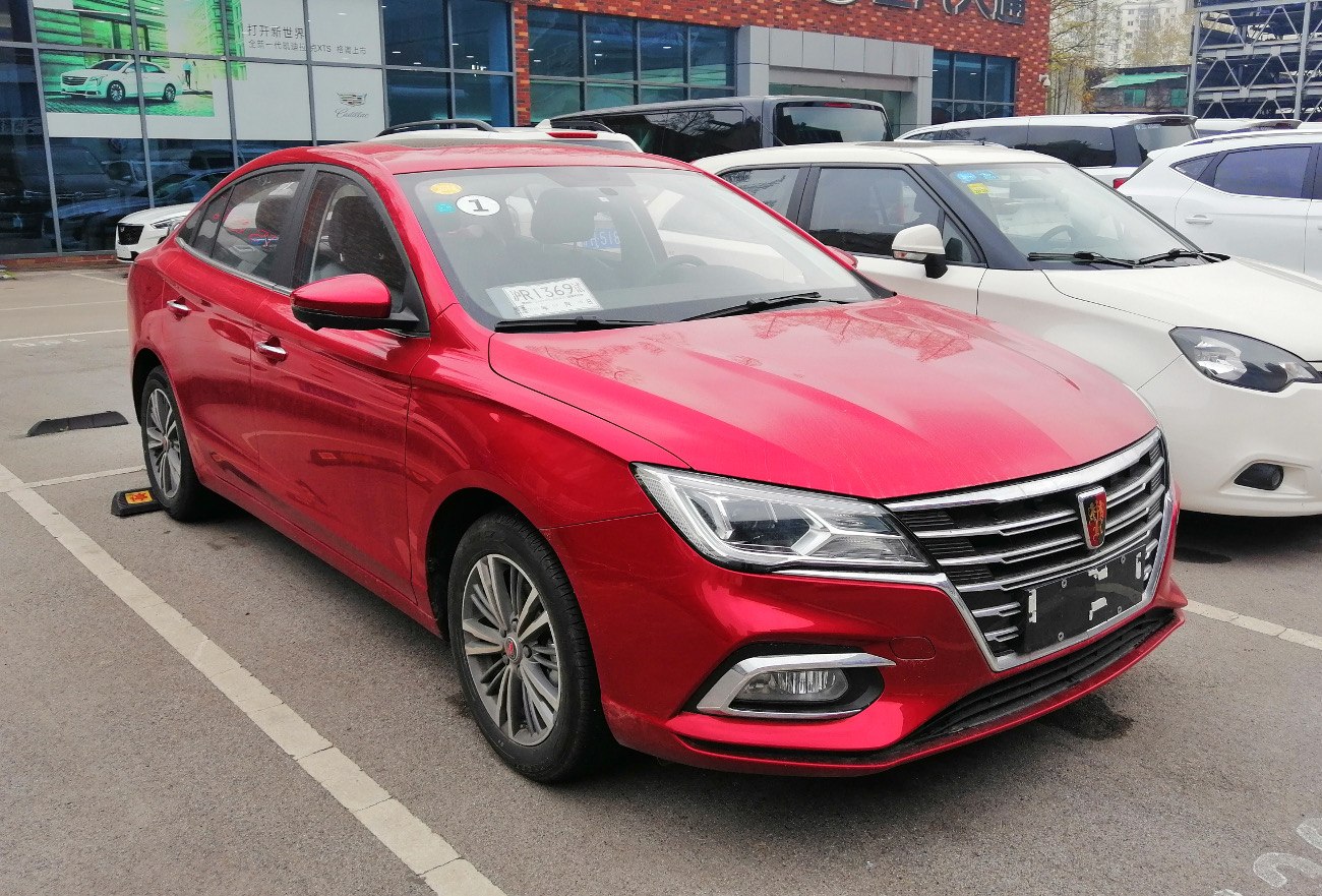 Red sedan with modern angular headlights and chrome grille