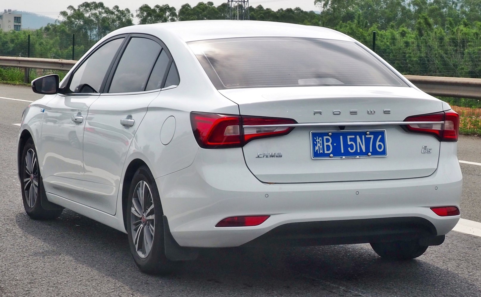 Rear view of white sedan with LED tail lights and smooth body lines.