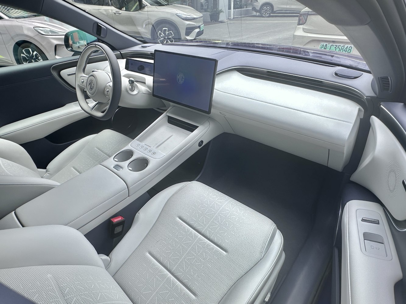 Modern car interior with digital dashboard and large touchscreen.