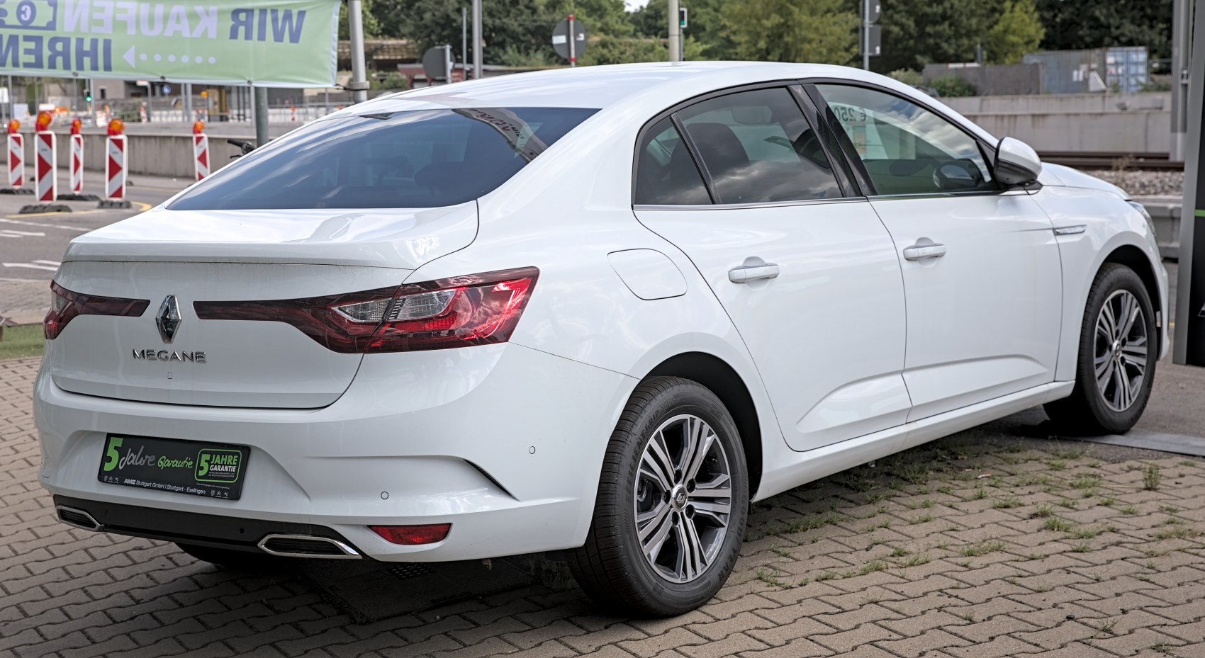 White sedan rear and side view with sleek taillights and alloy wheels