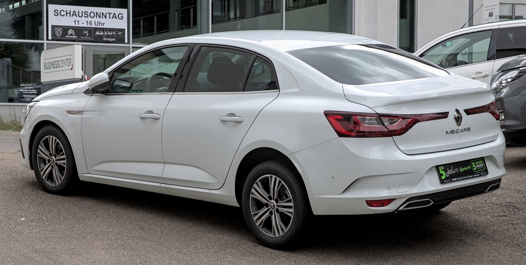 Rear and side view of a white modern sedan with sculpted body and distinctive taillights