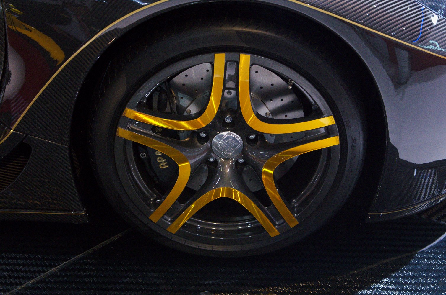 Black and gold alloy wheel with carbon fiber accents