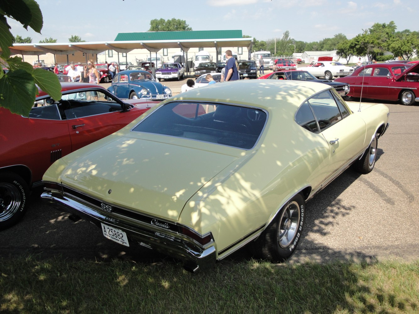 Rear view of a yellow vintage muscle coup&eacute; with SS badge and chrome bumper.