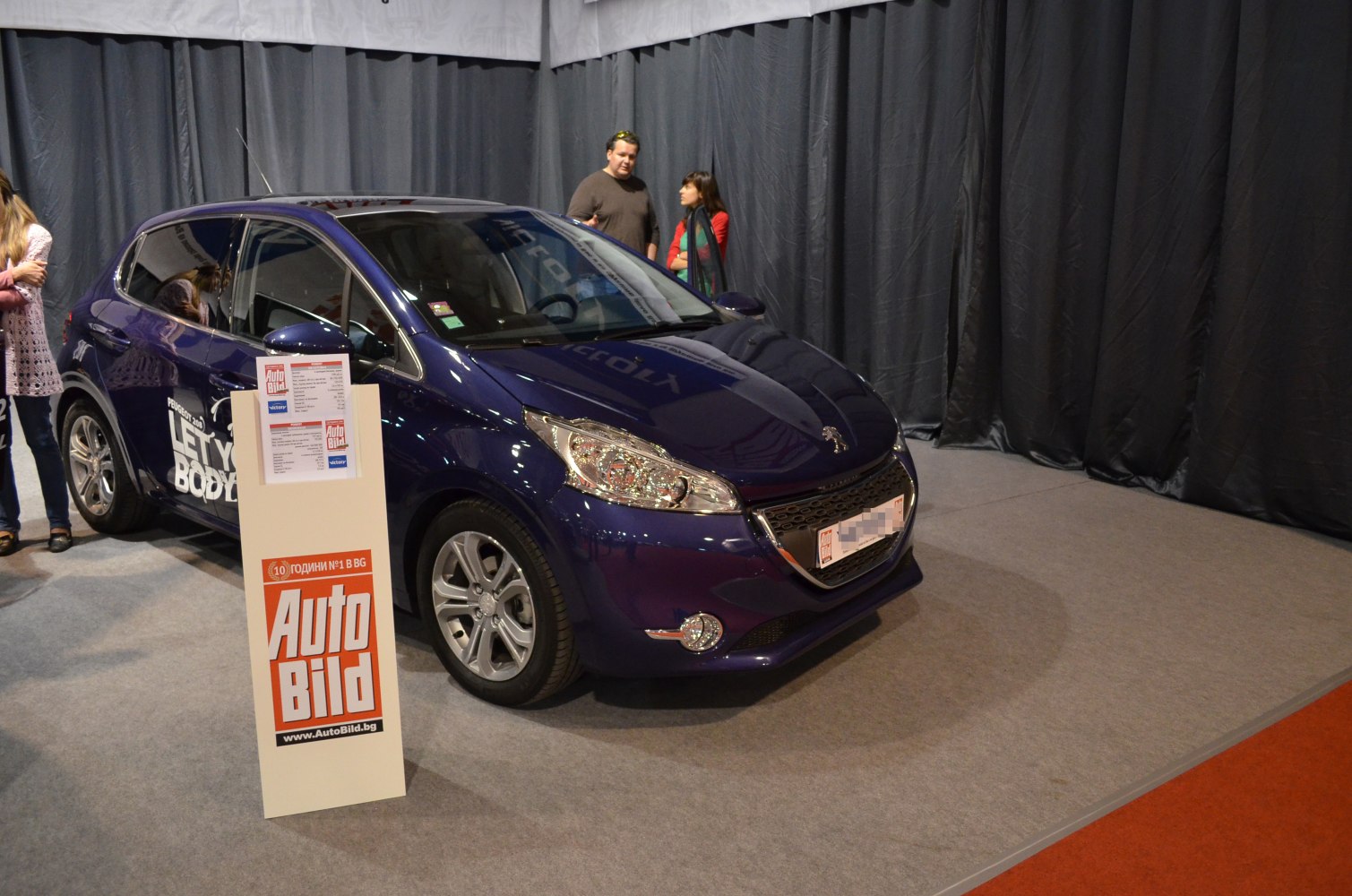 Front and side view of a blue hatchback with headlight and alloy wheel details.
