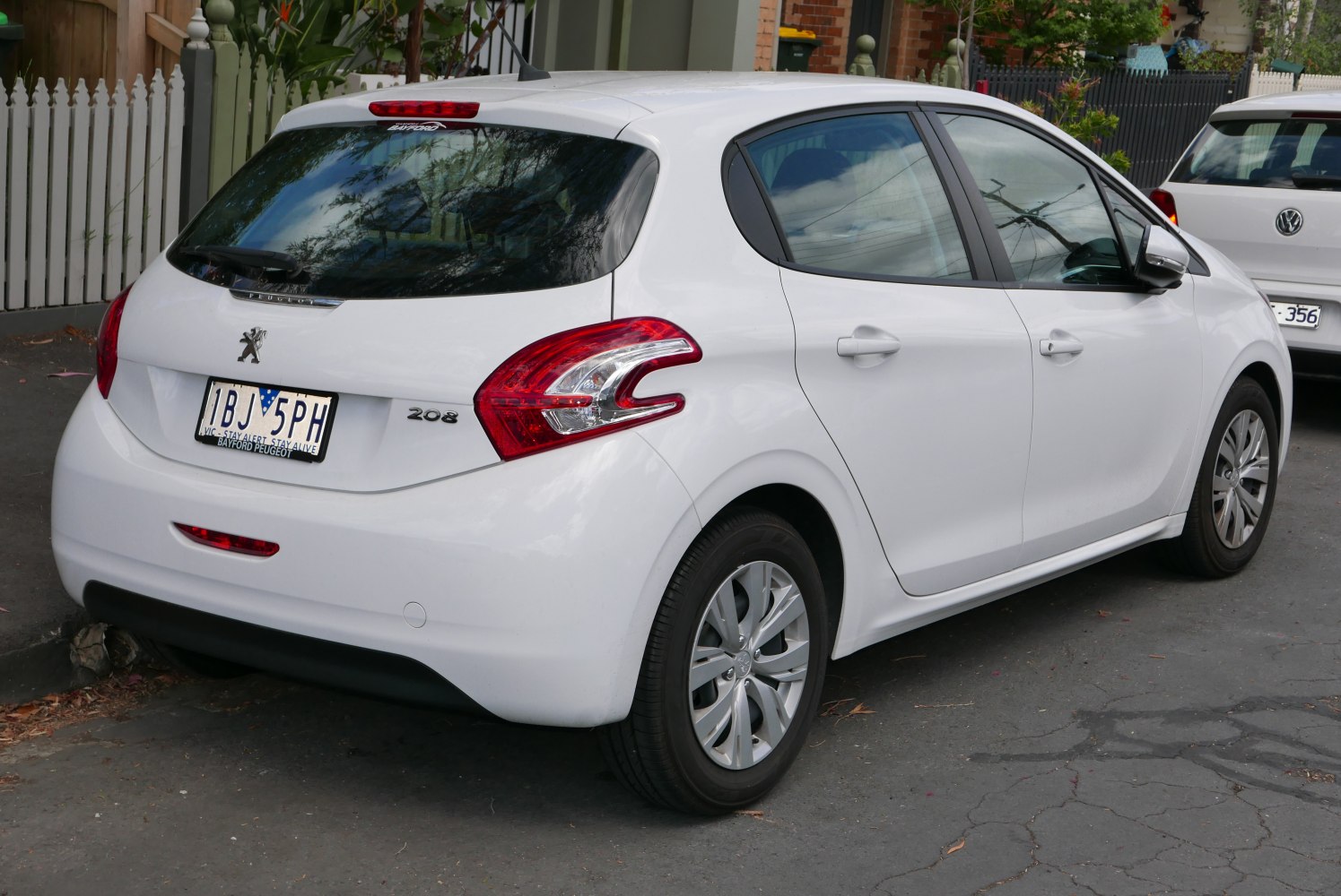 Rear and side view of a white hatchback showing tail lights and door handles
