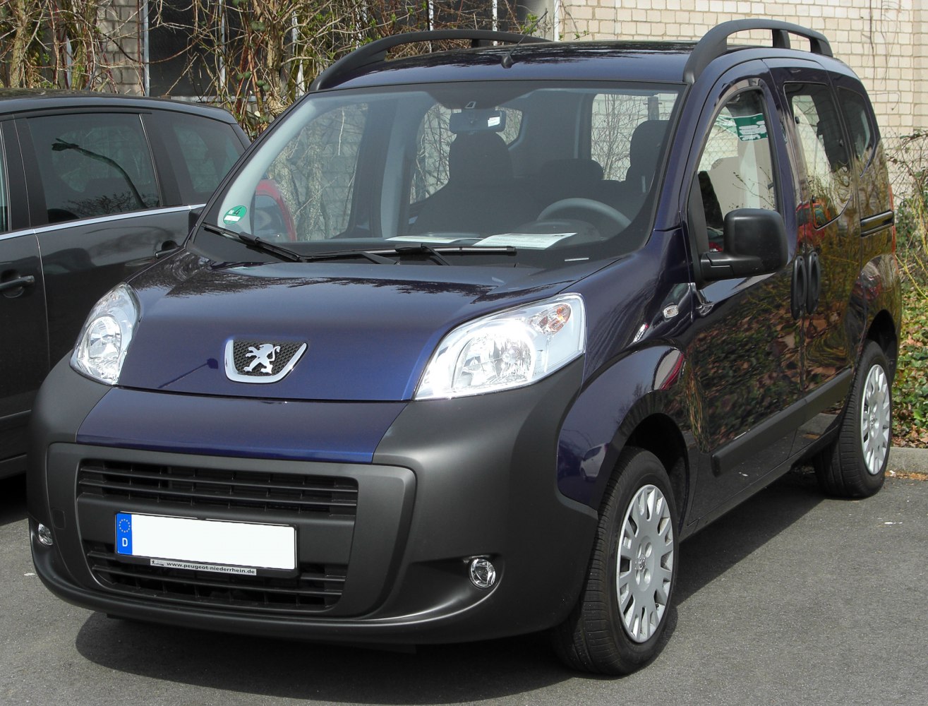 Front view of compact MPV with roof rails and sliding side door