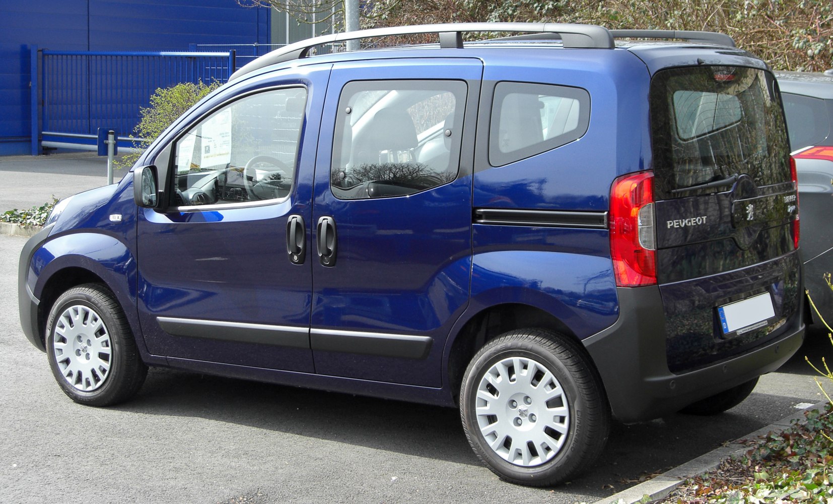 Compact panel van side view with sliding doors and roof rails