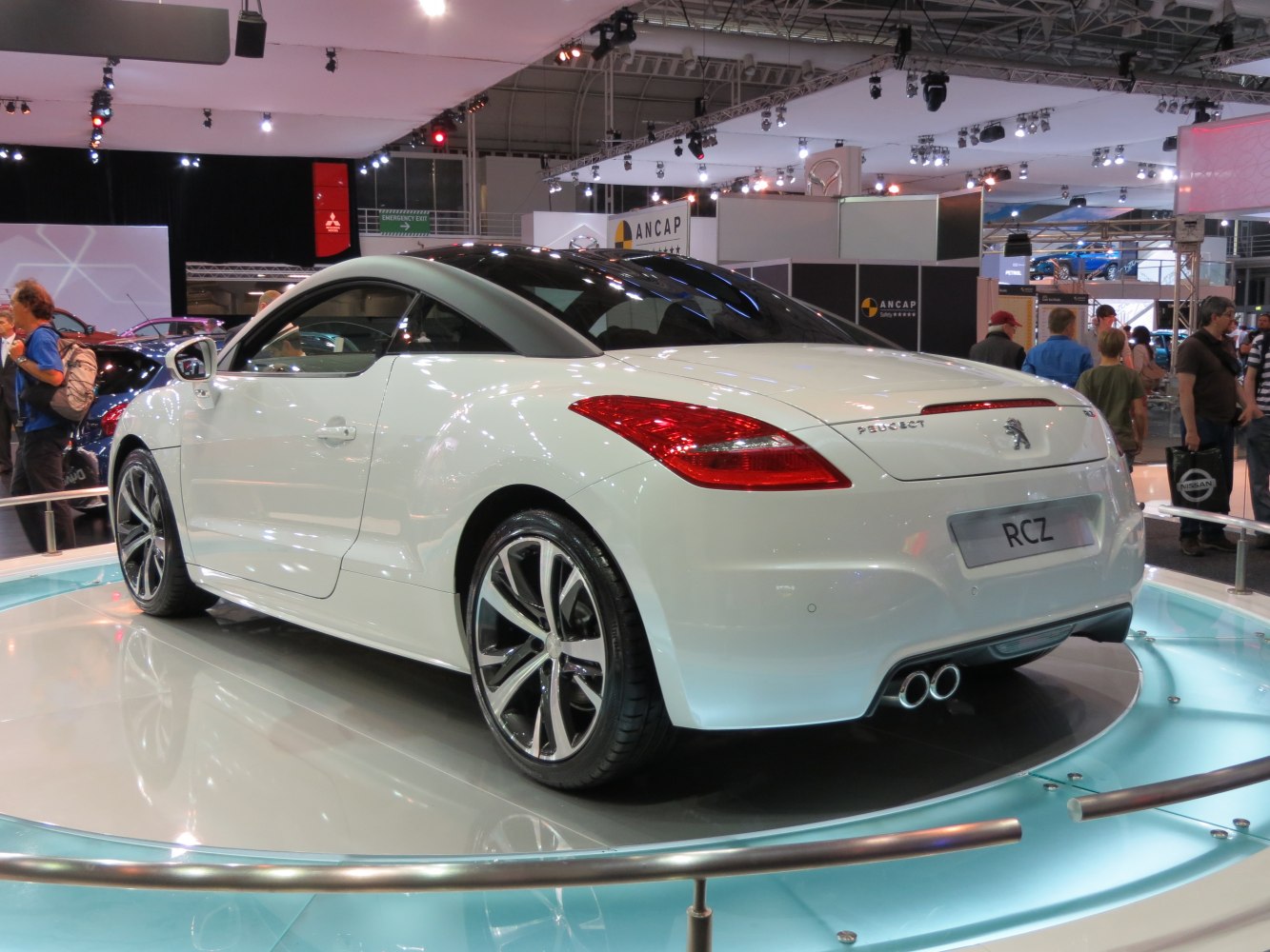 Rear and side profile of a sporty coupe with dual exhaust pipes and sleek curves.