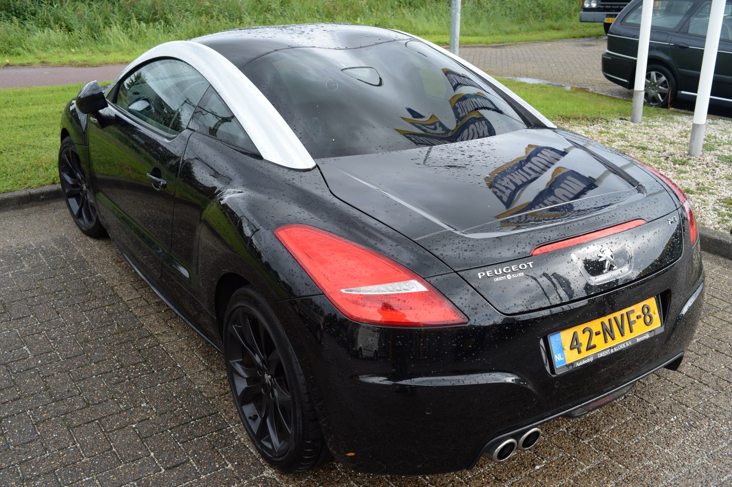 Rear view of black coupe with double bubble roof and dual exhaust.