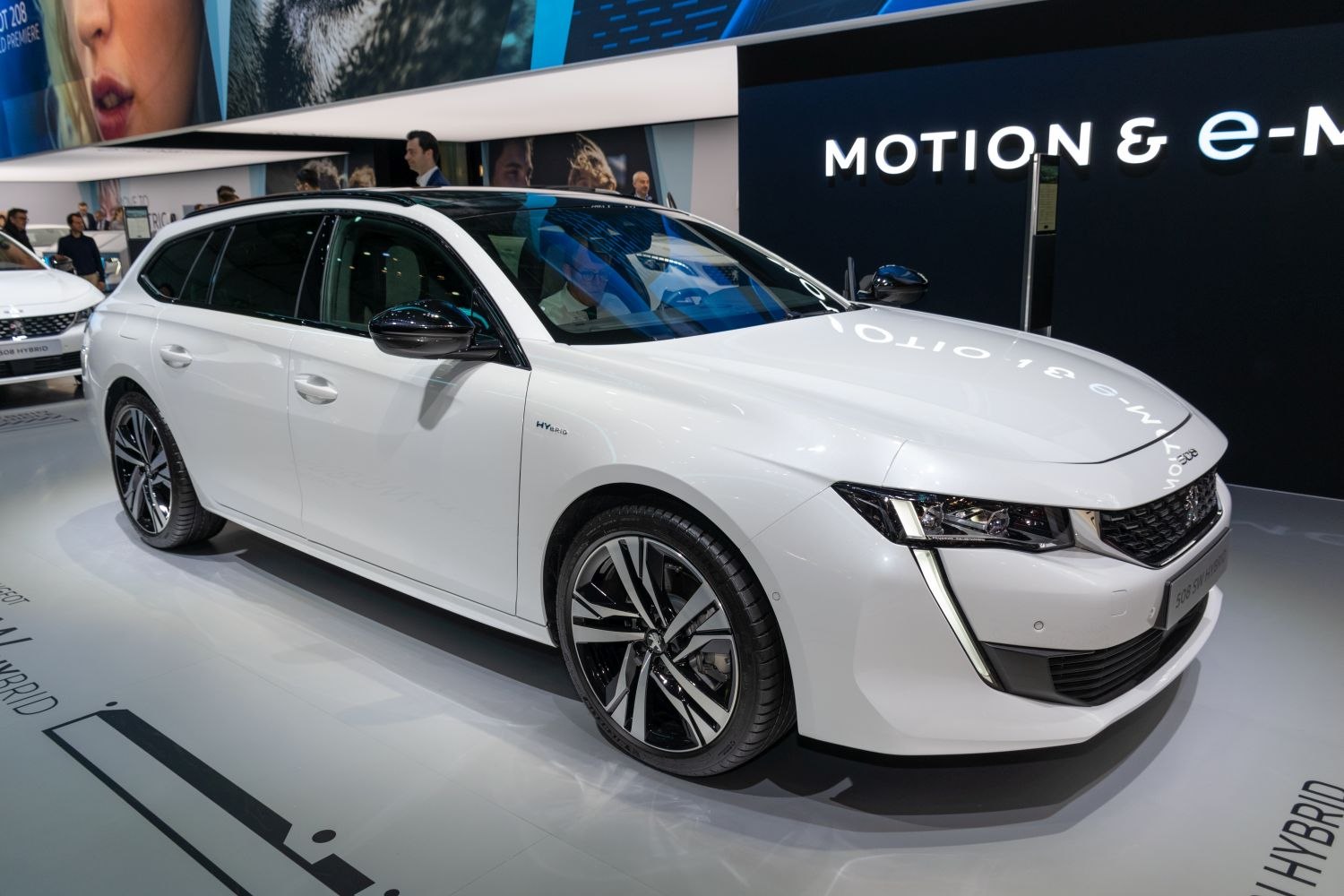 White hybrid station wagon with LED headlights and black roof rails
