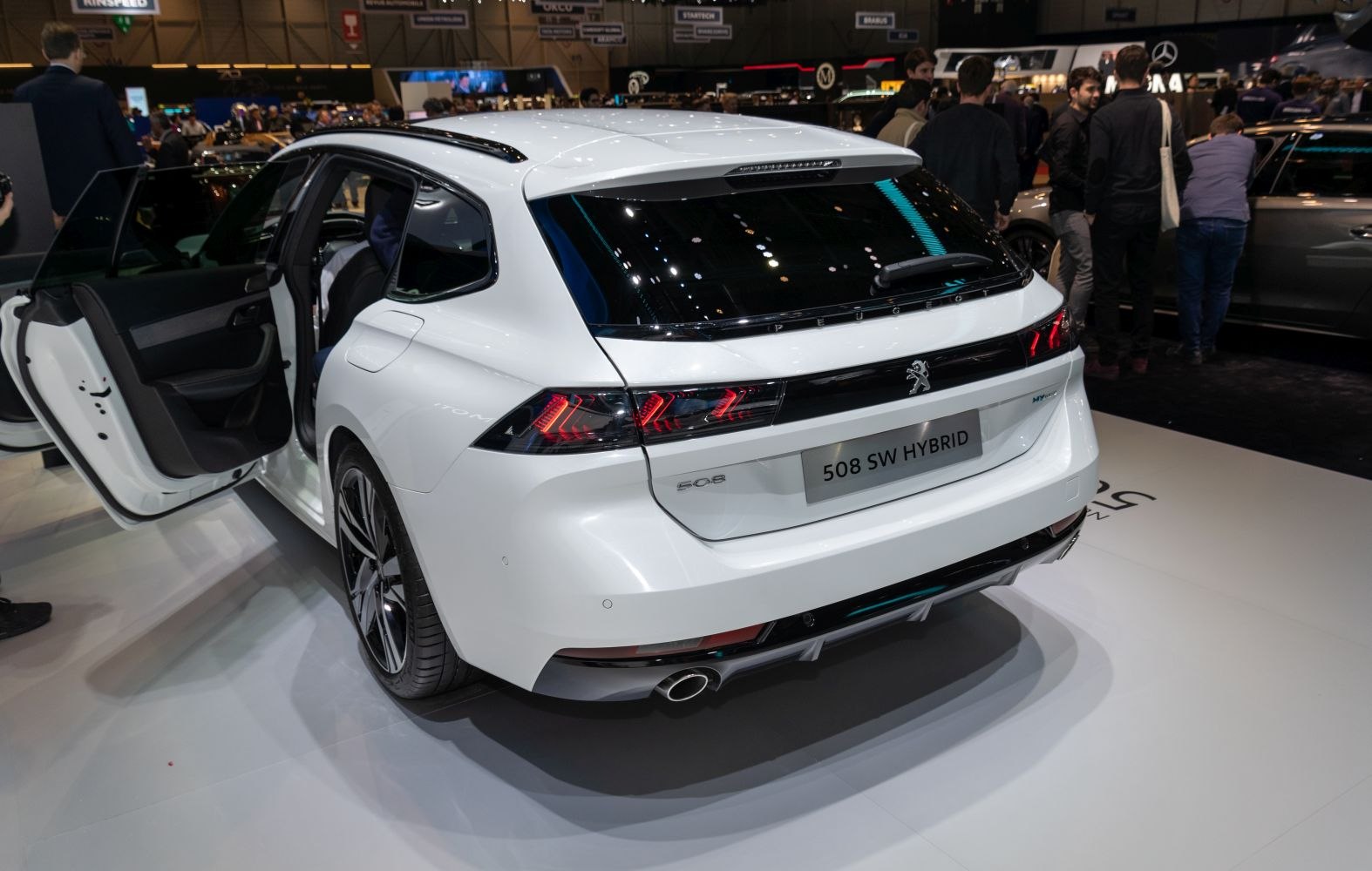 Rear and side view with open door, LED taillights, hybrid badge, and alloy wheels