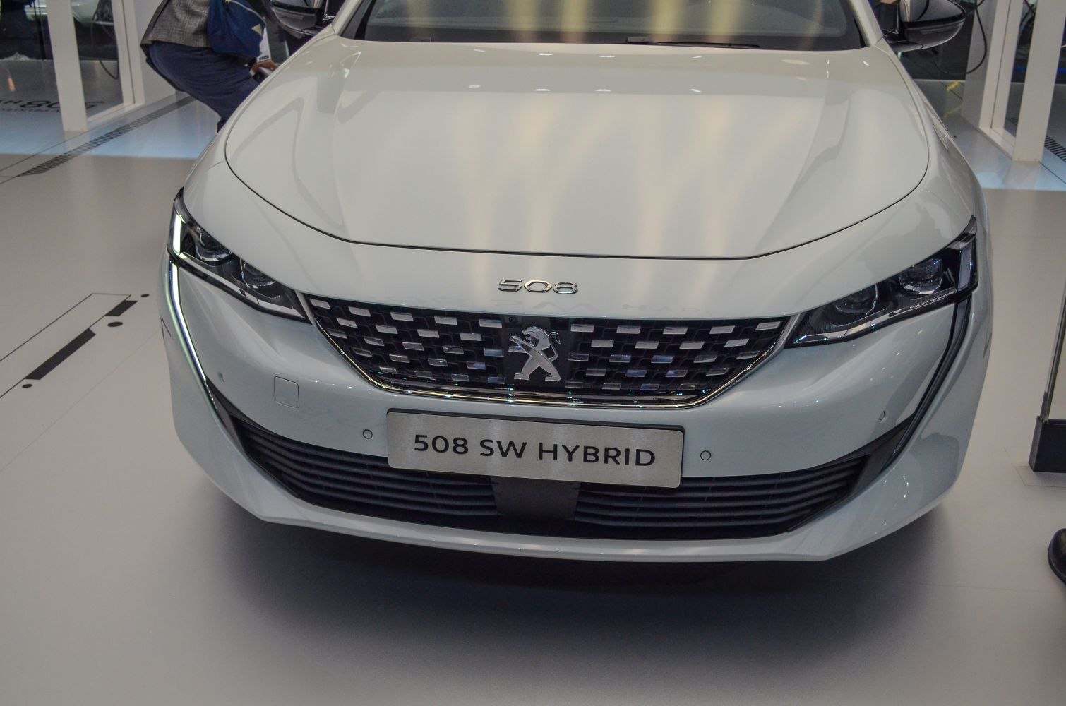 Close-up of front grille and LED headlights with hybrid badge