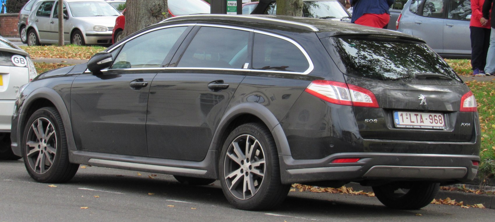 Black cross-over style station wagon rear-side view with alloy wheels and body cladding