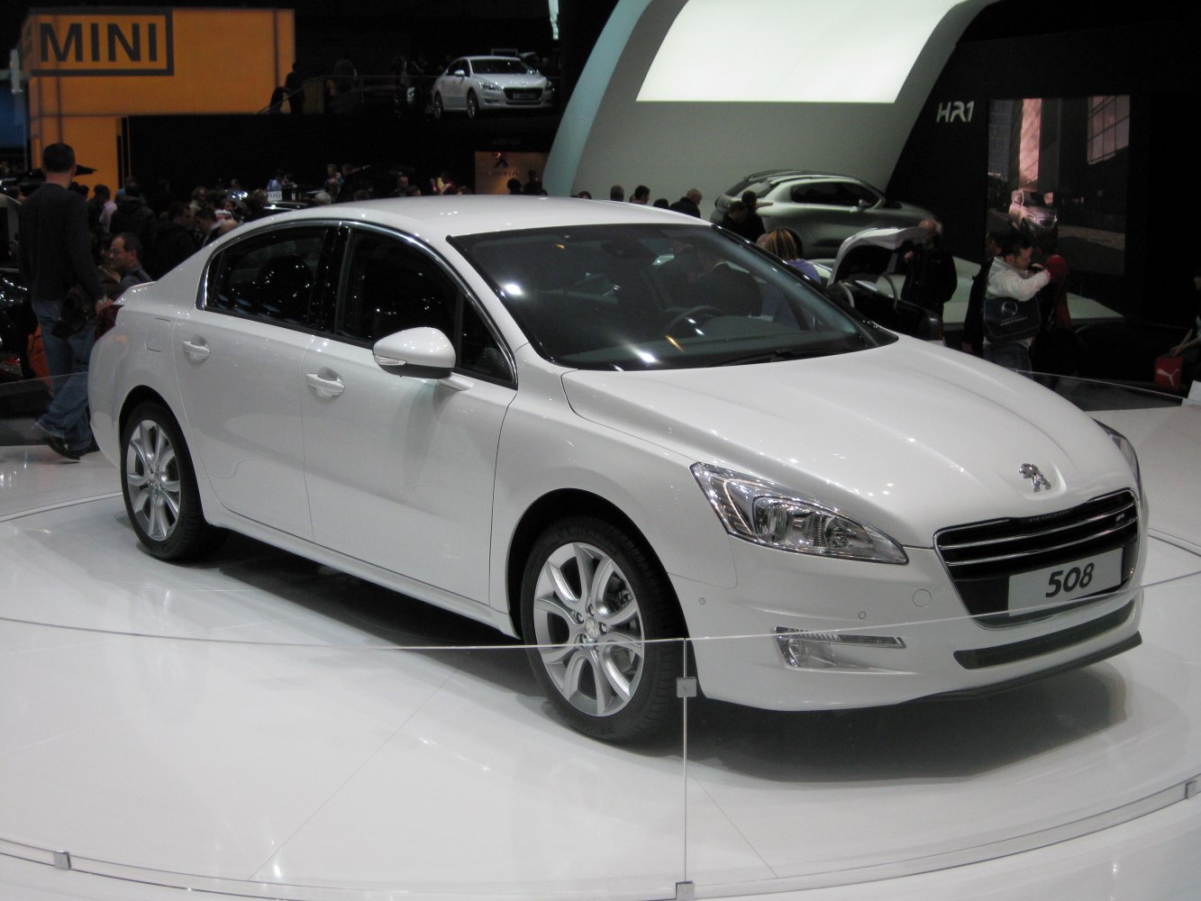 White midsize sedan with stylish headlights and alloy wheels