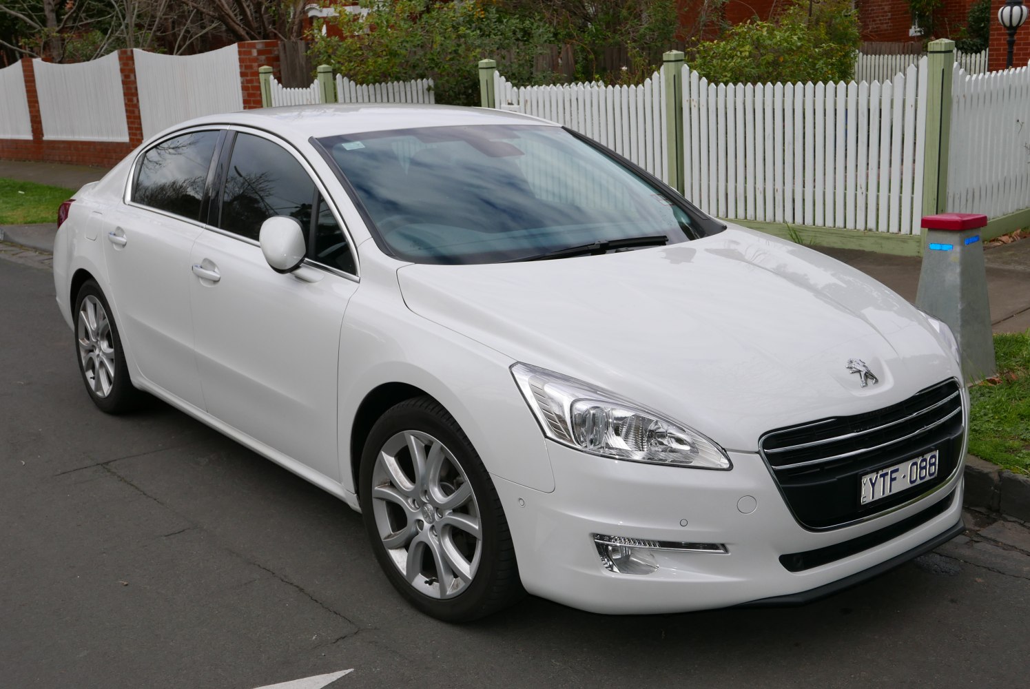 White sedan with prominent headlights and alloy wheels