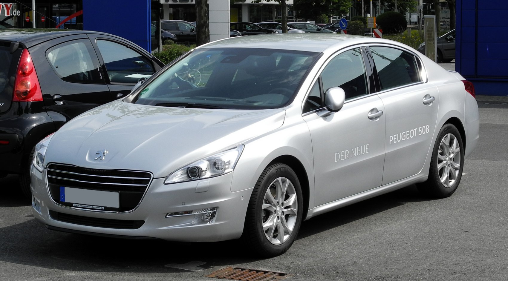 Silver four-door sedan with front grille and alloy wheels