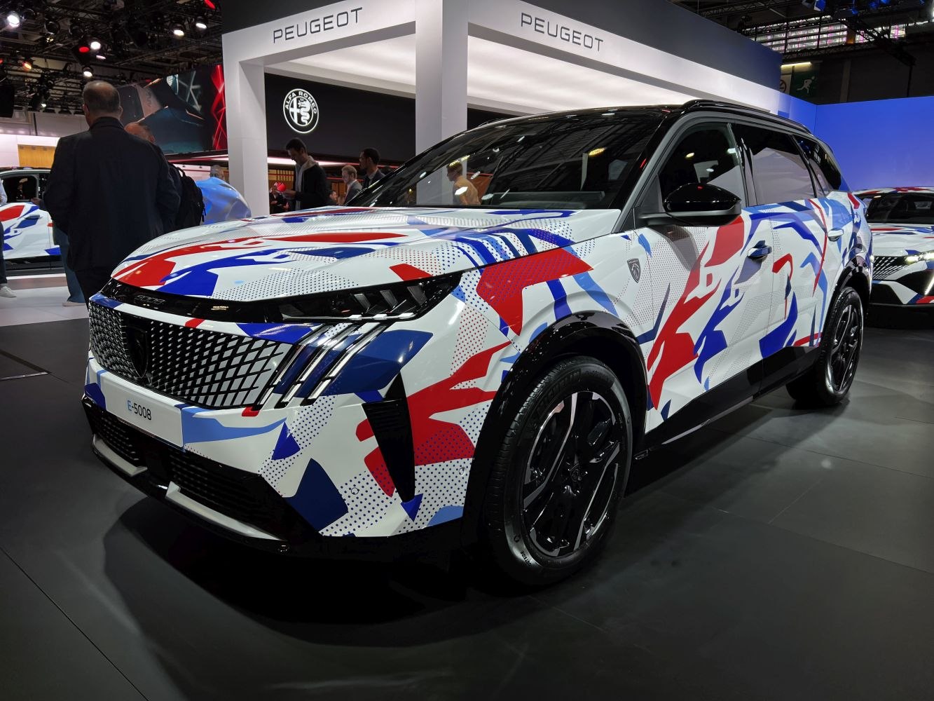 Front and side view of SUV with distinctive camo paint and grille