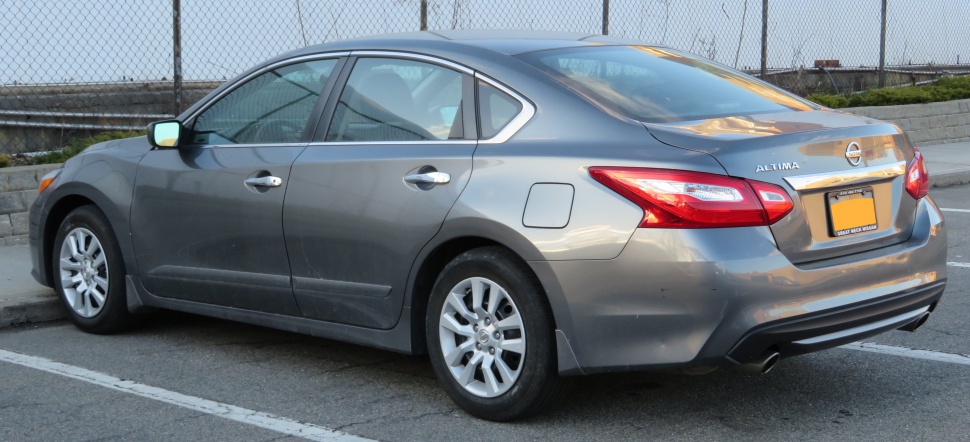 Rear side view of gray sedan with distinct taillights and alloy wheels
