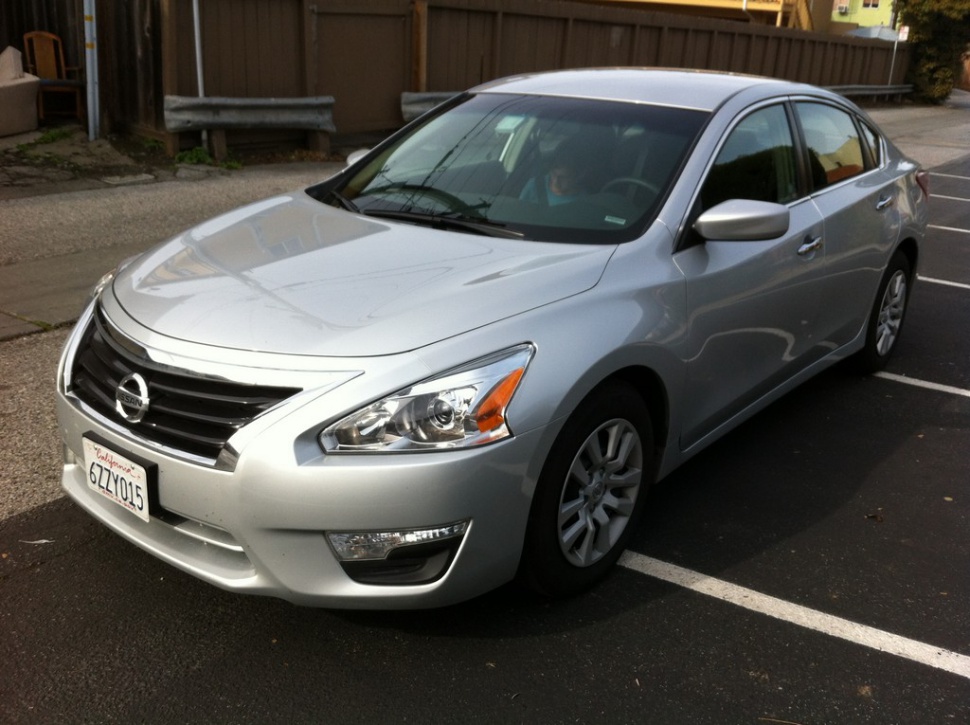 Mid-size sedan front-side view with prominent grille and LED daytime running lights